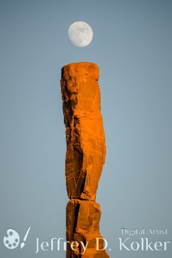 iMoon The moon rises above the Totem Pole, a rock formation found in Monument Valley, Arizona. It appears the moon is dotting the stone pillar to form a natural small...